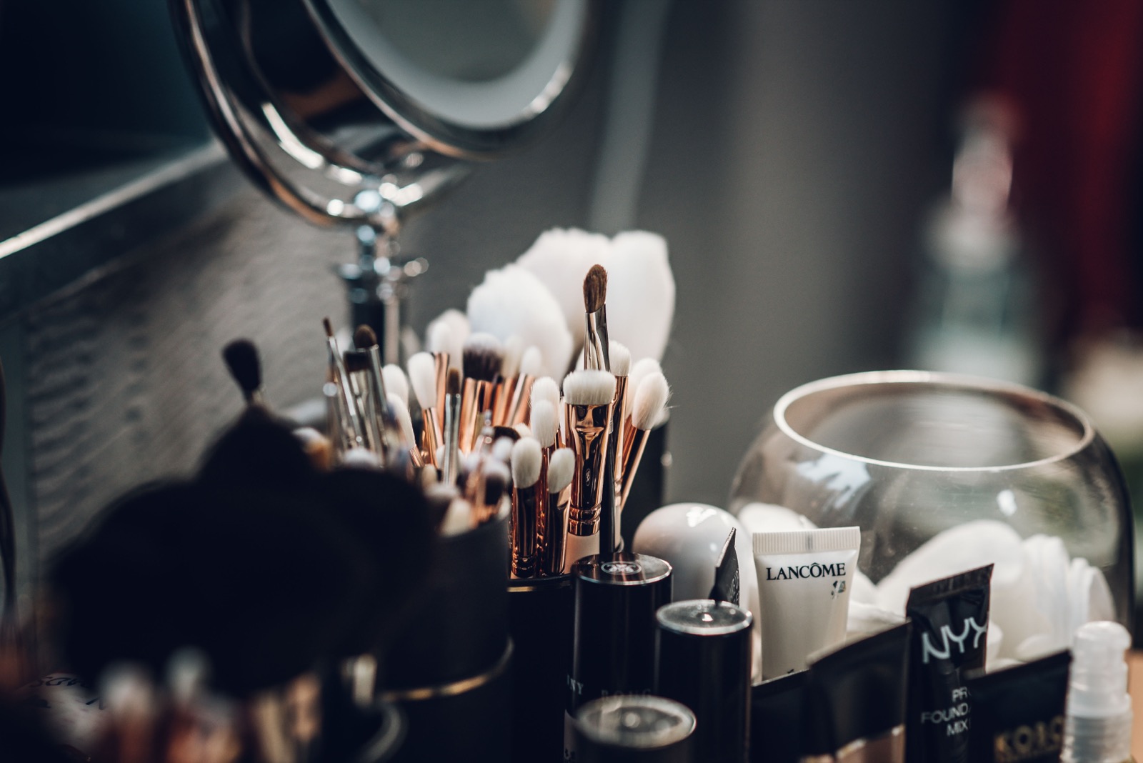 Beauty products and makeup brushes on a vanity